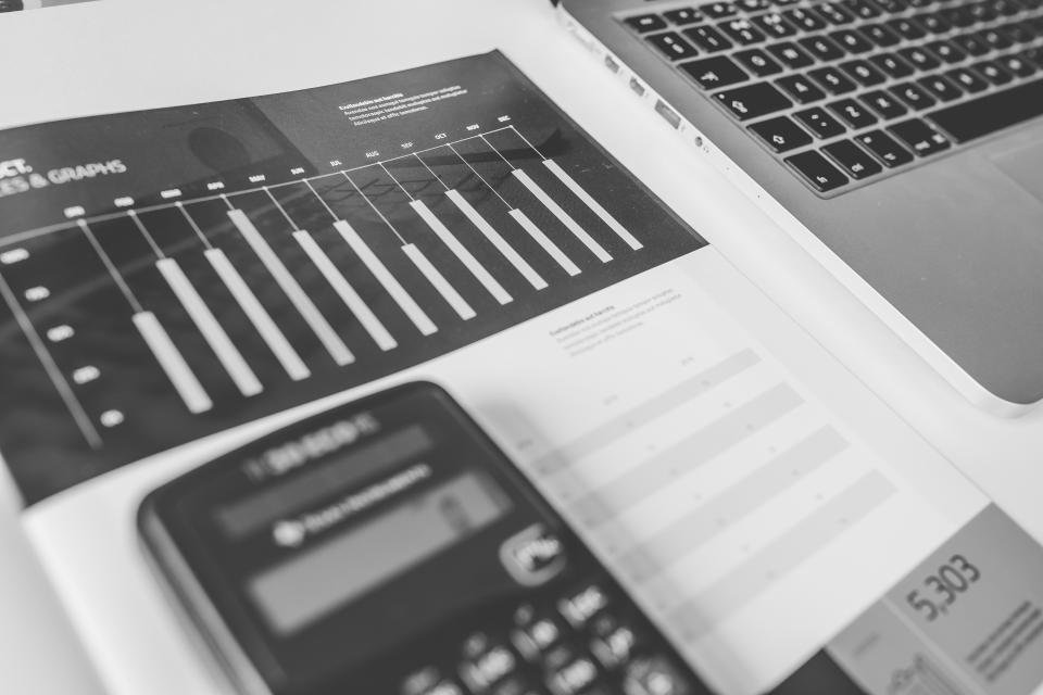 Calculator resting on printed financial charts